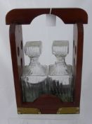 A Mahogany Tantalus having two cut glass decanters.