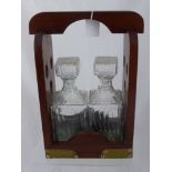 A Mahogany Tantalus having two cut glass decanters.