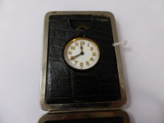 A Travelling Alarm Clock, in the original leather case,.