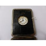 A Travelling Alarm Clock, in the original leather case,.