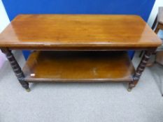 An Edwardian two tiered coffee table with turned supports and brass ball feet. Approx 120cm x 51cm x