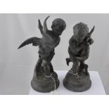 A pair of bronze effect cherubs, one holding a goose, the other a hare, approx. height 27 cms.