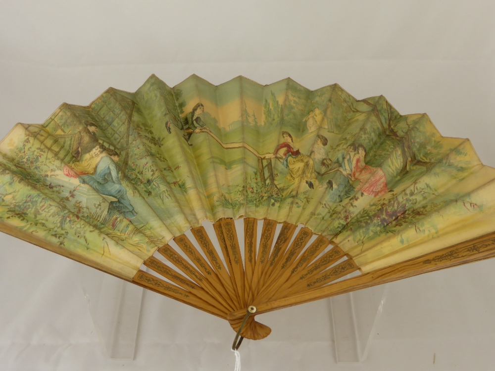 A Late 19th Century Lady's Fan, the fan hand painted with a scene of a family at play in a garden,