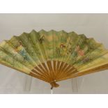 A Late 19th Century Lady's Fan, the fan hand painted with a scene of a family at play in a garden,