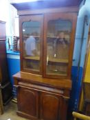 A  Edwardian mahogany glass fronted bookcase on base. The base having two doors to front and a