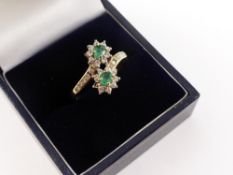 A Ladies 18 ct Gold Diamond and Emerald Crossover Cluster Ring. 2 x 3.8 x 3 mm emeralds, 27 dias 1.5