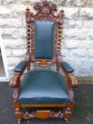 Two 20th Century Carved Oak Throne Chairs. The highly decorative chairs bear carvings to the top