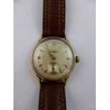 A Gentleman's 9 ct Gold Longines Wrist Watch. The watch having a silvered engine turned face with