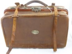 A vintage leather travelling case having a metal plaque to one side  " M Stephan ", the case also