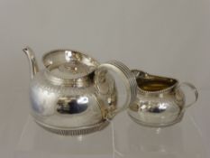 A Solid Silver Teapot, London hallmark, both being of rib design with foliate engraving and beaded