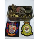 A Tin Box containing miscellaneous military buttons and cap badges, including North Stafford,