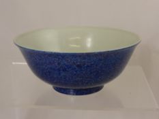 A deep blue Chinese porcelain bowl depicting dragons amongst cloud scrolls and flaming pearls of