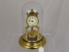 A Brass Pendulum Clock under a glass dome.