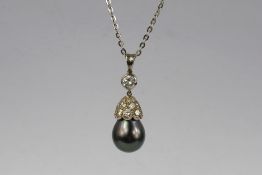 An 18 ct White Gold Tahitian Pearl and Diamond Drop Pendant. The pearl set to a diamond bud form