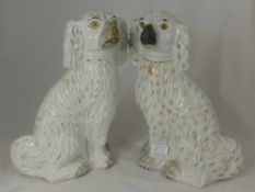 A pair of white and gilt ceramic figures in the form of spaniels, approx. 34 cms. in height (2)