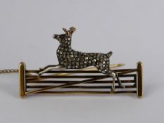 An 18 ct Diamond and Ruby Deer Brooch. The brooch having a stylised deer set with ruby eyes and rose