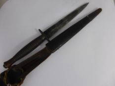 A WWII Fairbairn Sykes Commando Fighting Knife with original scabbard. The blade retains some of its