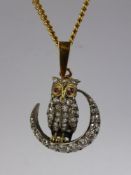 An 18 ct Yellow Gold, Silver, Diamond and Ruby Owl Pendant. The owl having ruby eyes and resting