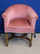 An Oak Framed Boudoir Tub Chair covered in pink velour, the front legs having bobbin style
