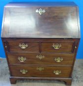 A Georgian Mahogany and Oak Bureau having two short and two long drawers on bracket feet, the