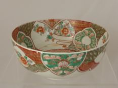 An oriental style ceramic bowl decorated with flora and fauna to the inside and outside of the