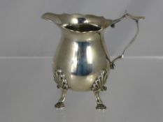 A Silver Cream Jug, shaped rim and handle with a simple body raised on four hoof feet, approx 80