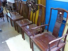 A Set of Six Oriental Style Fruit Wood Dining Chairs includes two carvers.