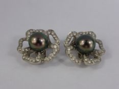 A Pair of Platinum and Tahitian Pearl Clip Earrings. The floral design earrings set with  2 x 10