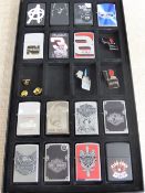 A Collection of Fifteen Zippo Lighters, in a glass covered collectors display case. Included amongst