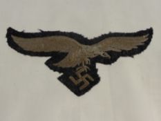 A German Nazi Luftwaffe Cloth Uniform Badge, together with a German U-Boat button a cap badge and