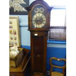 An antique oak long case clock, the face being brass and silver metal with Roman numerals, the clock