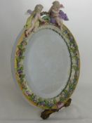 A Lady's Meissen Easel Mirror, with applied floral decoration to the frame and cherubs clasping a