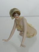 1920's German Bisque Bathing Beauty, depicted seated with legs curled beneath her, leaning forward