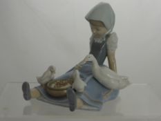 A Lladro Figure of a Young Girl Feeding Ducks, impressed marks to base D-19 A, 18 cms high.