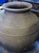 A Large Vintage Dark Terracotta Portuguese Olive Oil Amphora 72 cms high in stand 190 cms girth.