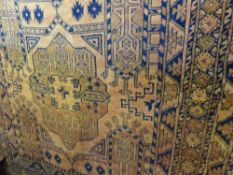 A Middle Eastern Wool Rug, the rug having two central guls with orange and navy background, approx