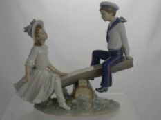 A Lladro Figure of a Young Girl and Boy on a see-saw, impressed marks to base F-11 MY, 24 cms high.