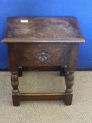 An Antique Occasional Table with a hinged lift up lid with floral carving to front panel on turned