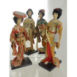 Four Japanese Figures, supported on ebonized plinths, depicting Geisha.