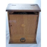 An Oak Tobacco Cabinet, with the original Royal Doulton tobacco pot, fitted interior and a single