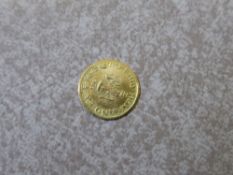 A Fine Gold Mexican Maximillian Coin dated 1865, wt 0.1 gm.