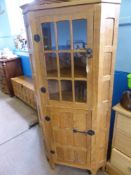 A Sid Pollard Oak Panelled Corner Cabinet, glazed fronted door panel enclosing two shelves above a