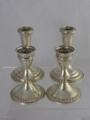 Two American Poole Candle Sticks, together with two others stamped Sterling to base. (4)