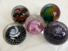 Five Caithness Glass Paper Weights, one entitled "Cauldron" black, "Cauldron" ruby, "Flamenco" pink,