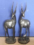 A Pair of Ebonised Carvings of Gazelle, one feeding a calf, 94 cms high. (waf).