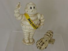 A Cast Iron Michelin Man Piggy Bank, 22 cms high, together with a cast iron door knocker in the form