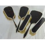 A Tortoiseshell Dressing Table Set comprising mirror, two hair brushes and two clothes brushes.