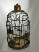 An Antique Brass Canary Cage, the cage having ceiling hook with hanging perch, feeding bowl and