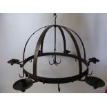 A Wrought Iron Game Crown with candle sconces and game hooks.