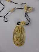 An Antique Chinese Ivory Carved Pendant Necklace, the filigree pendant depicting two figures in a